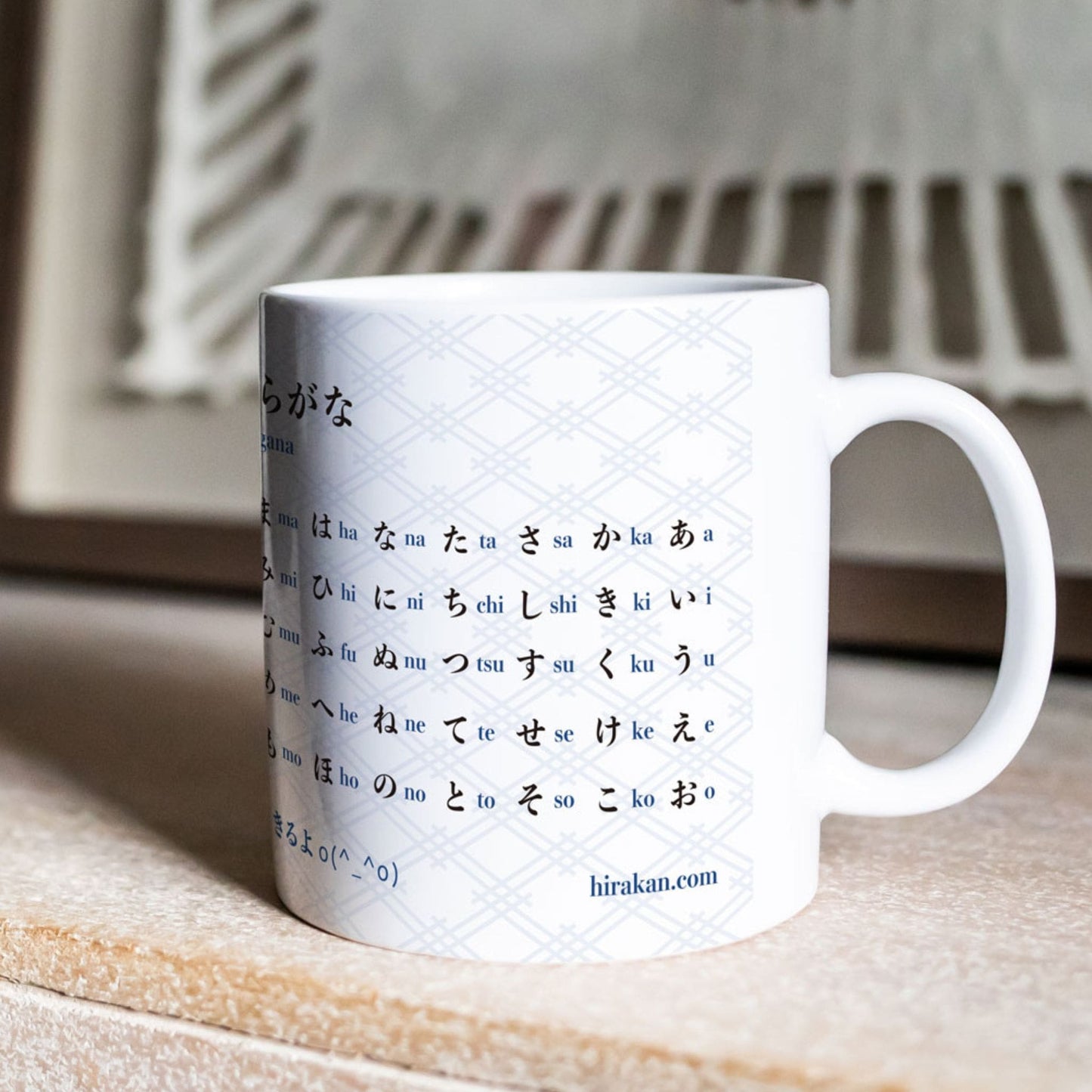Mug with hiragana chart print for Japanese language learning on a chest of drawers